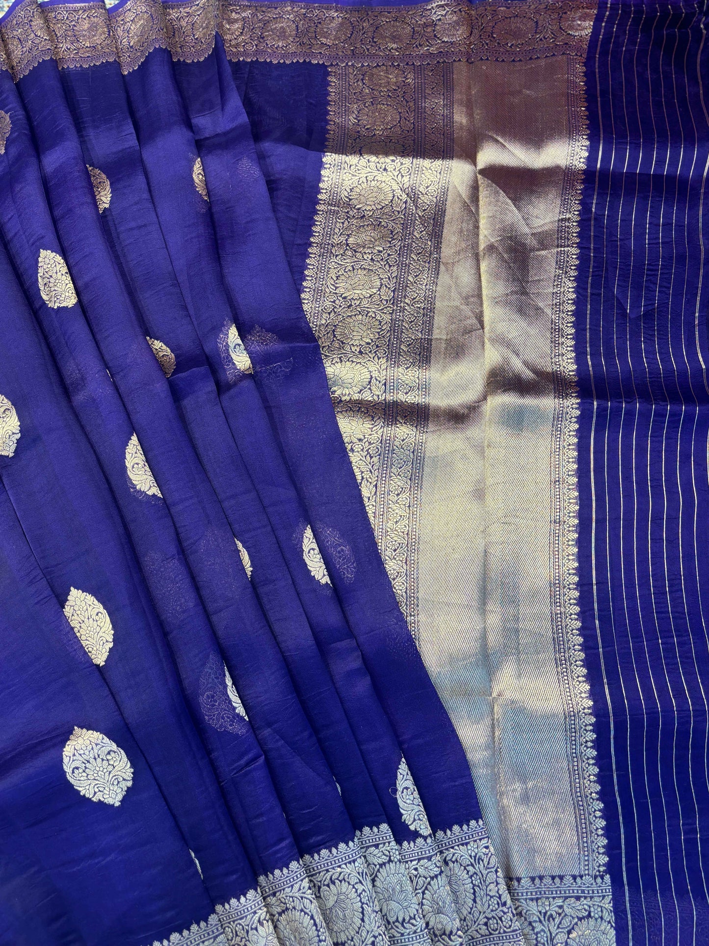 Blue saree pleats with gold motif repeats and silver-gray pallu panel