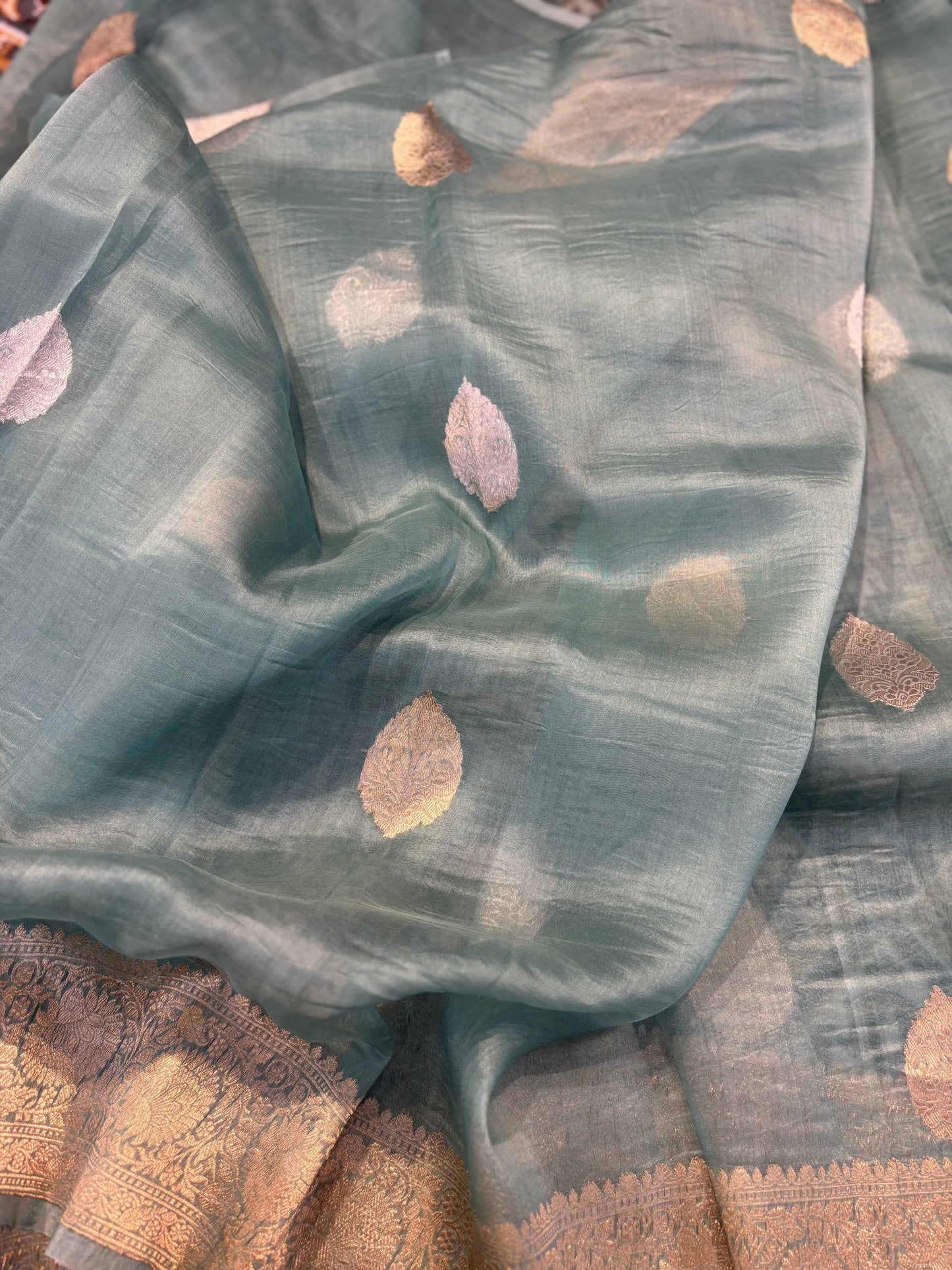 Powder-blue saree fabric with scattered oval zari motifs and gold trim