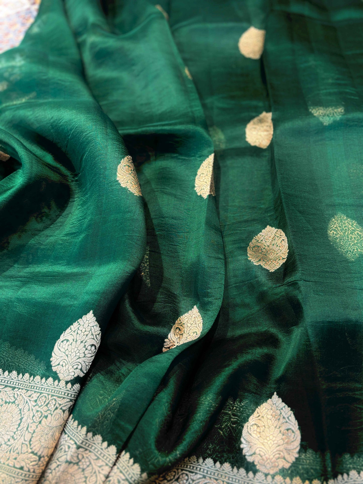 Green silk saree with scattered gold motifs and detailed woven border