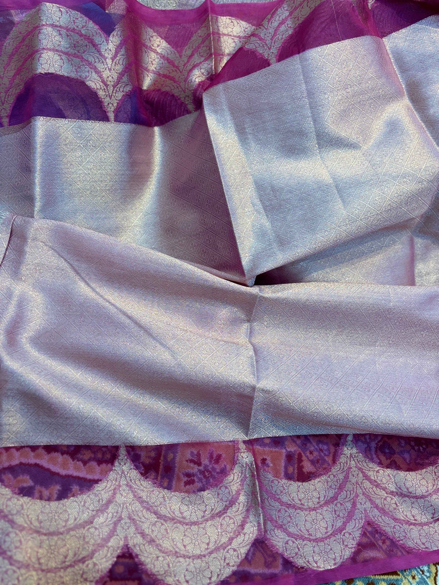 Close-up of woven saree fabric with purple medallion motifs and light satin panels