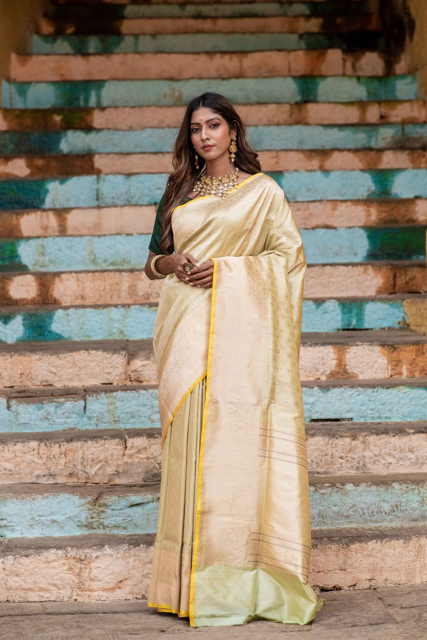 Light gold handloom saree with thin yellow border and intricate woven pattern, draped