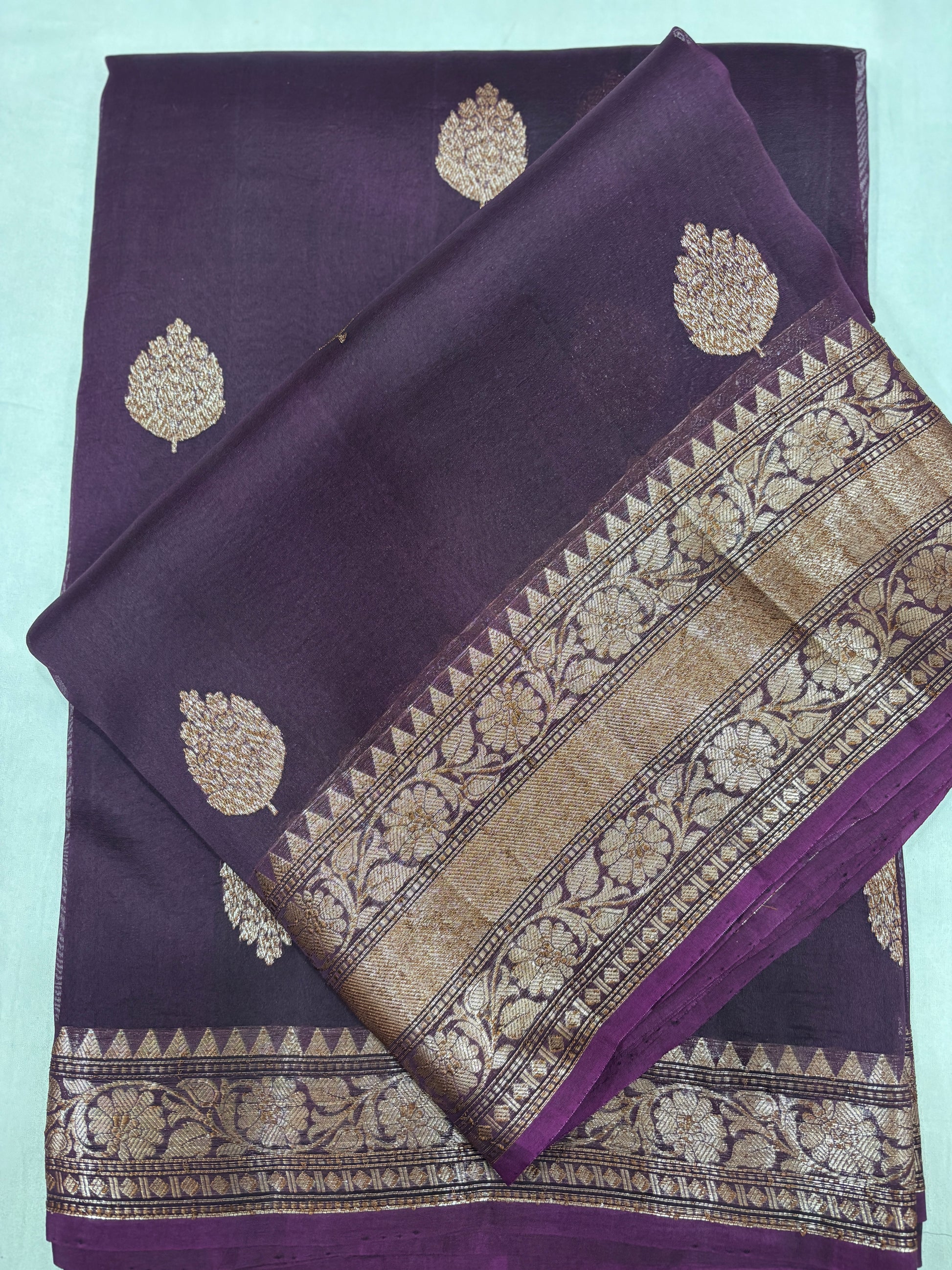 Purple silk saree with gold leaf motifs and gold zari border with floral weave