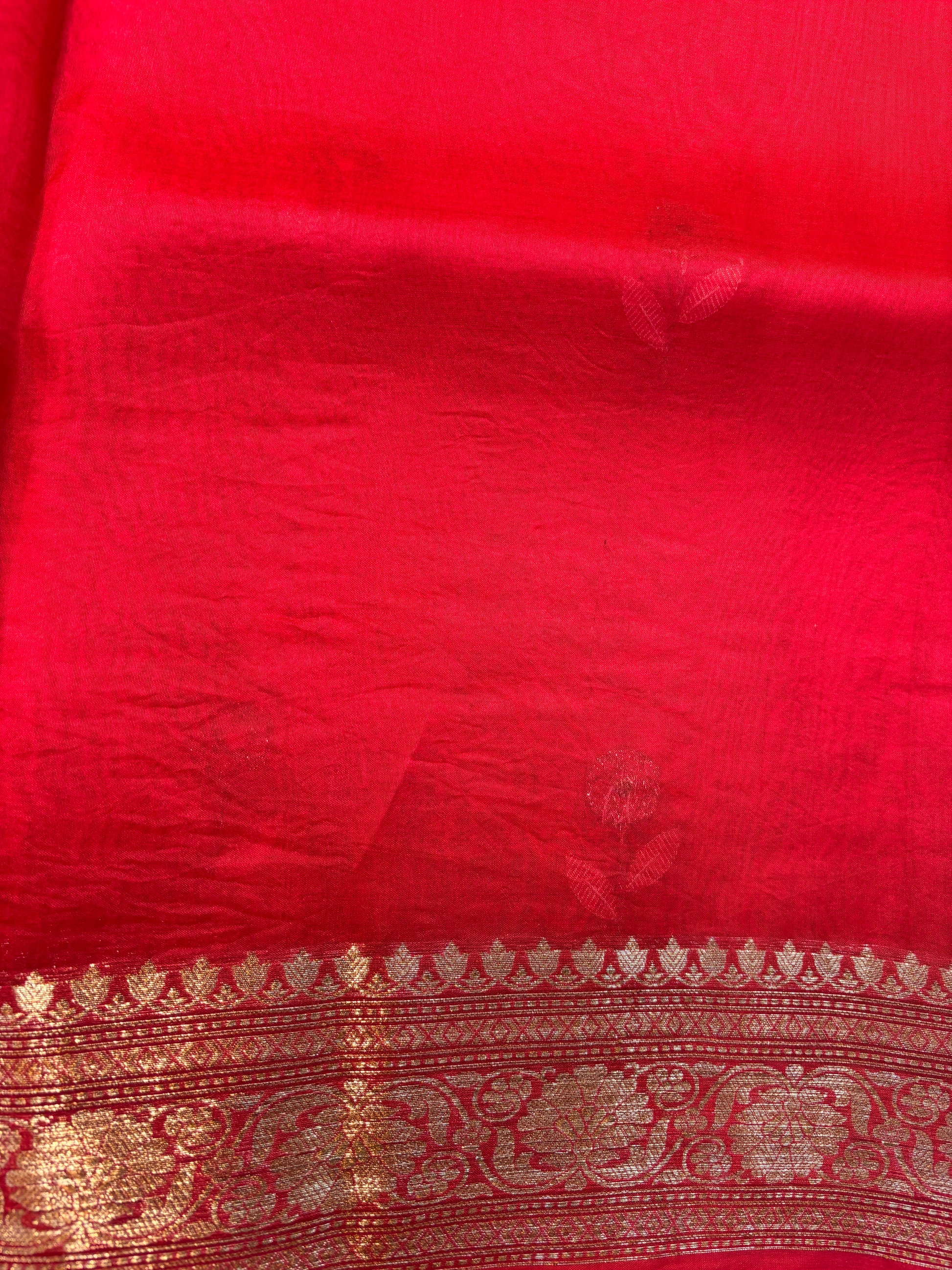 Red silk sari body with gold zari band and ornamental border, close-up