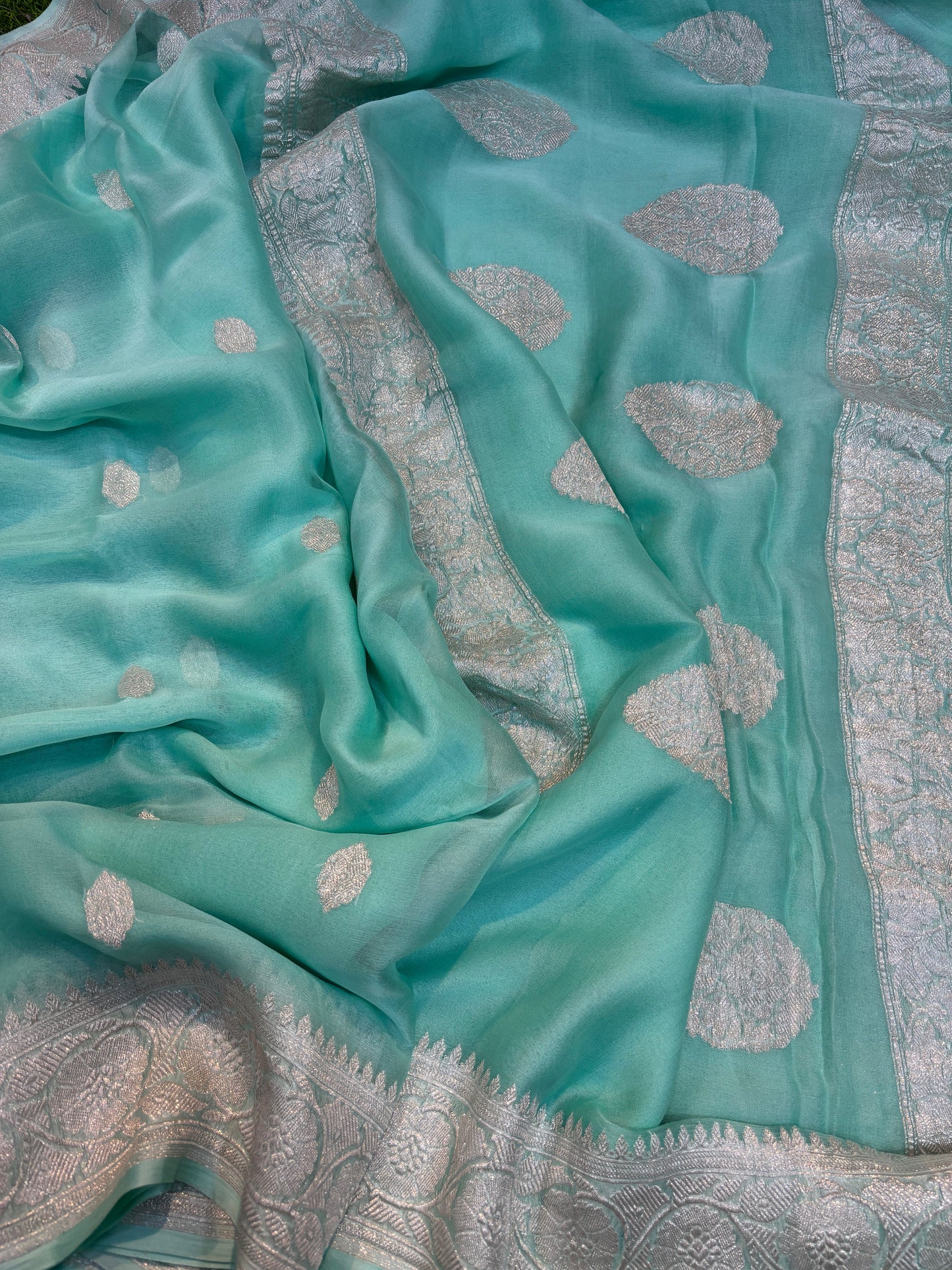 Teal chiffon saree with silver boota dots and wide ornate border panel
