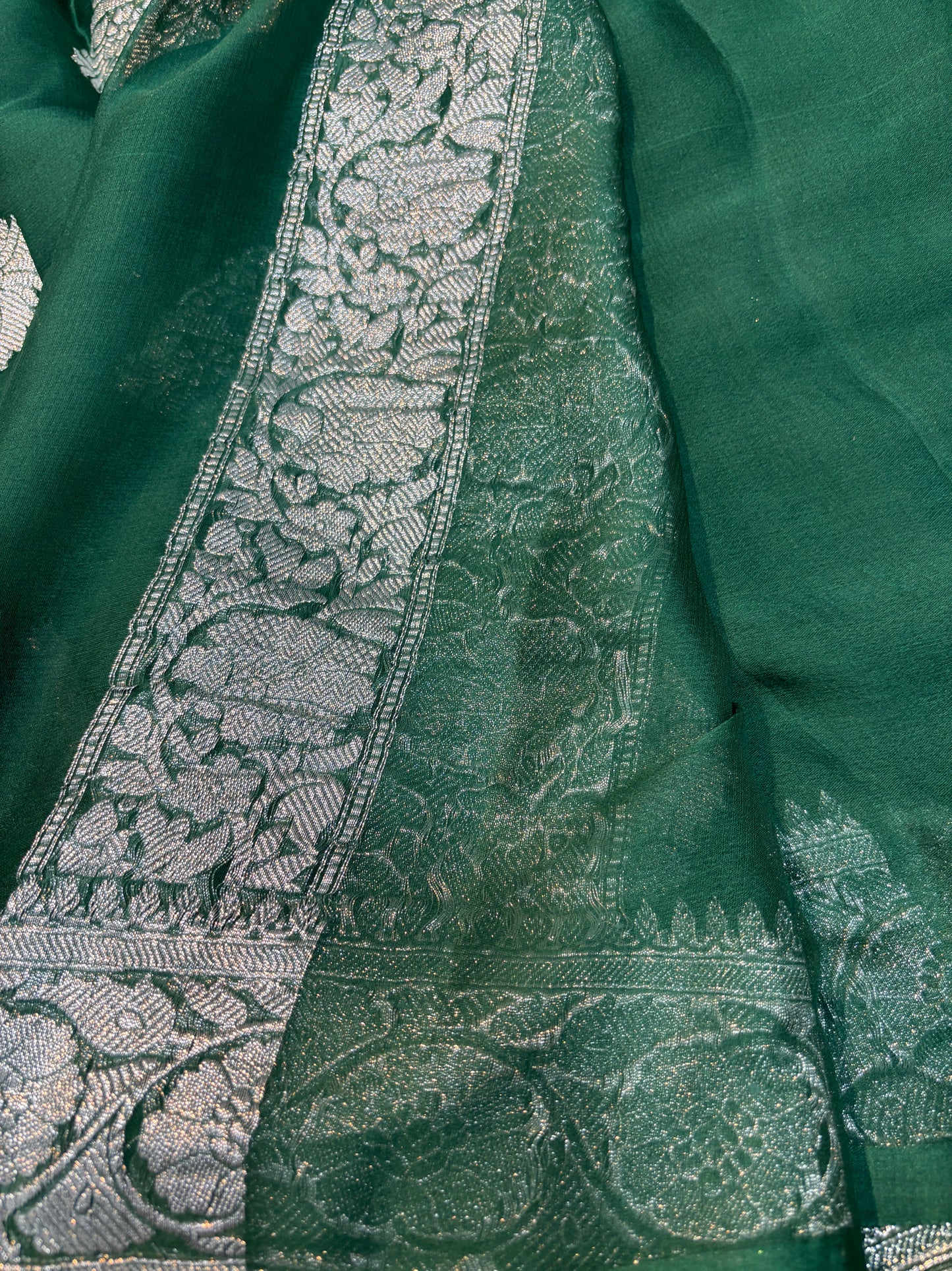 Teal chiffon saree with intricate silver border band and leaf-like pattern