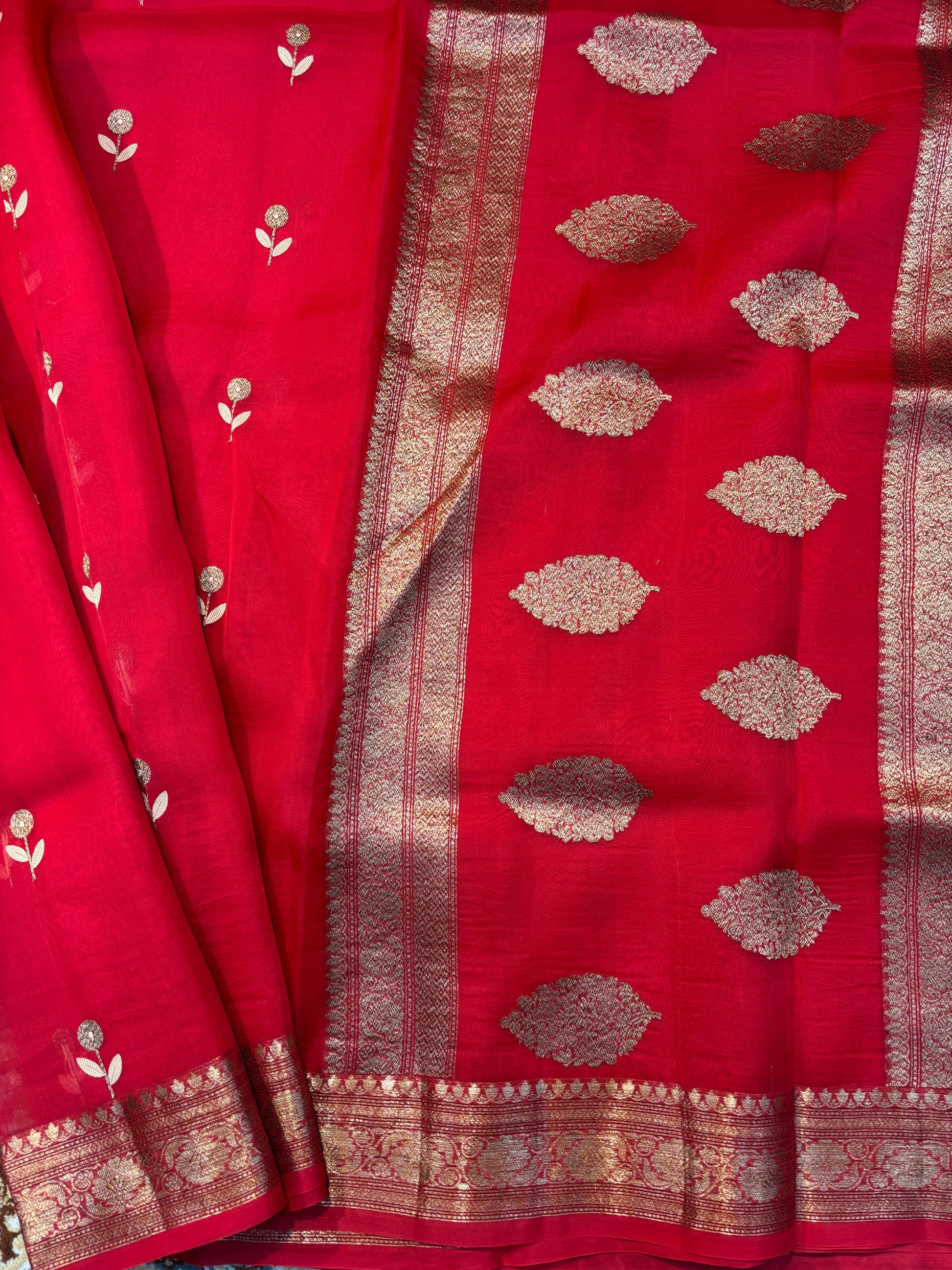 Red silk sari with gold zari border and repeated round coin motifs, close-up