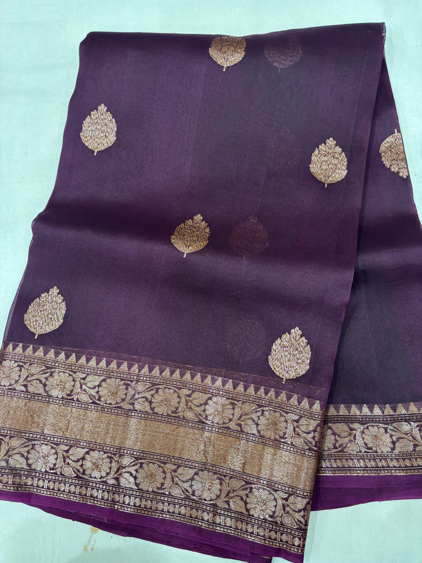 Purple silk saree with gold leaf motifs and wide zari border with floral patterns