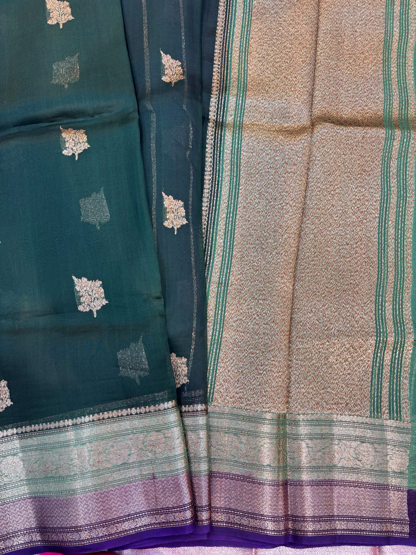 Teal handloom saree with small gold motifs, green woven border, and beige panel