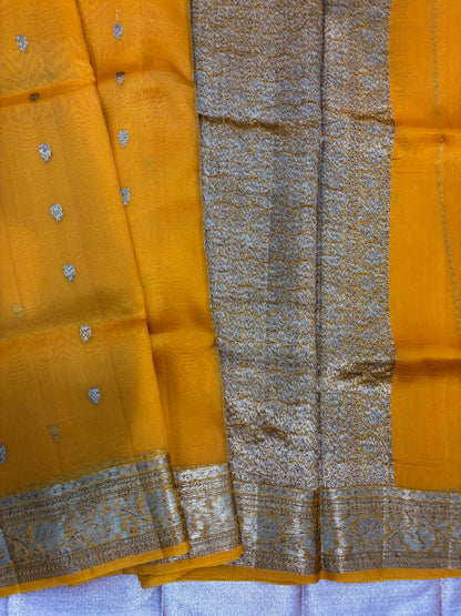 Mustard saree with silver dot motifs, wide silver border, and grey patterned panel