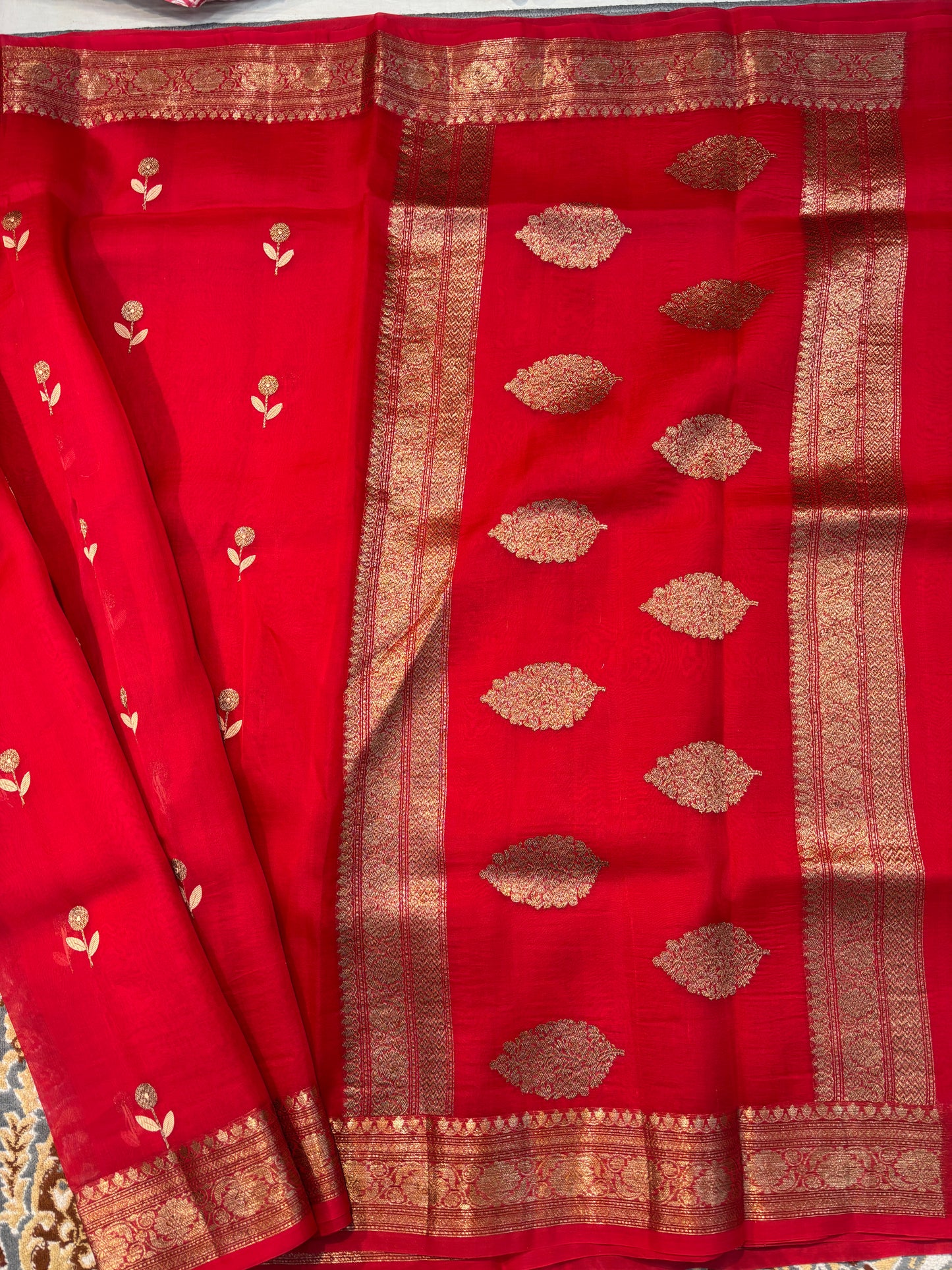 Red silk sari fabric with gold zari panel and round coin motifs on pallu