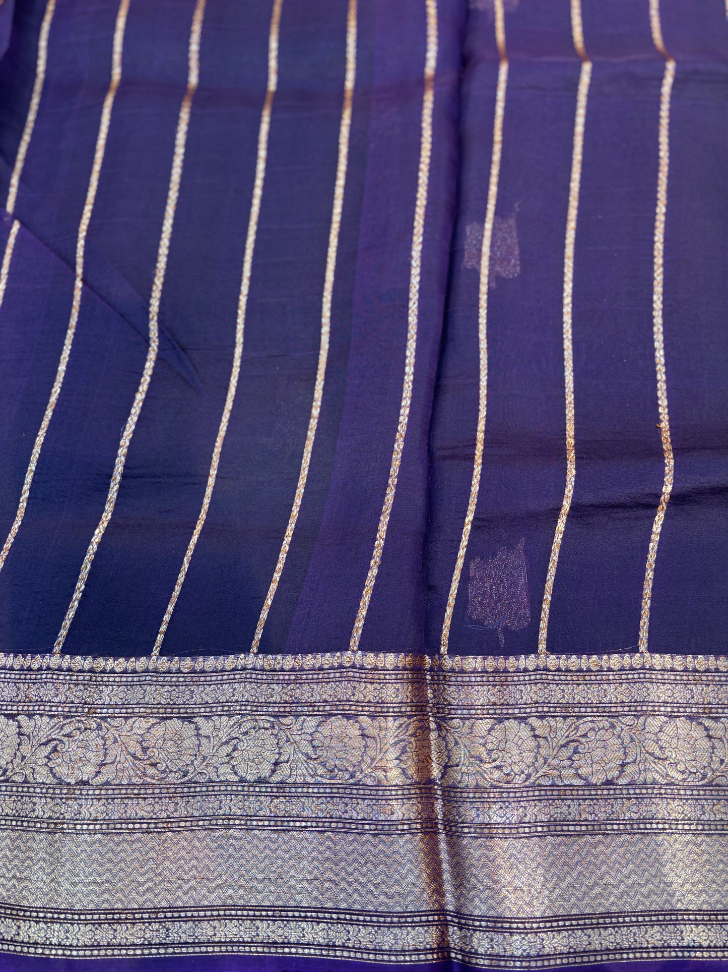Dark blue handloom saree with gold stripe pattern and ornate silver border