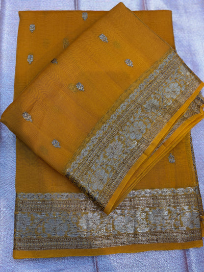 Mustard saree with silver dots, layered with matching silver zari border and draped pallu