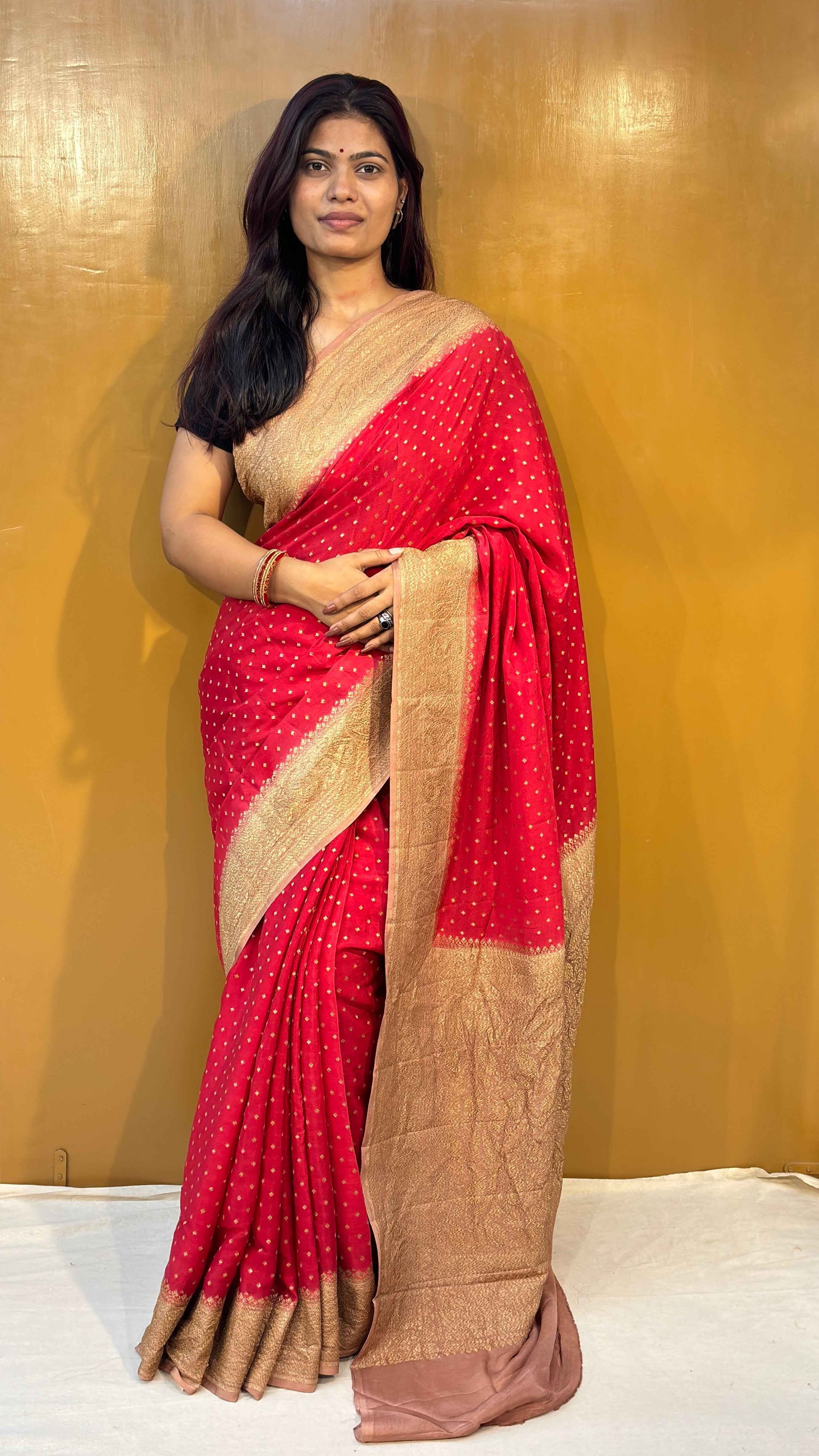 Red saree with wide gold zari border and draped pallu, handloom-style weave