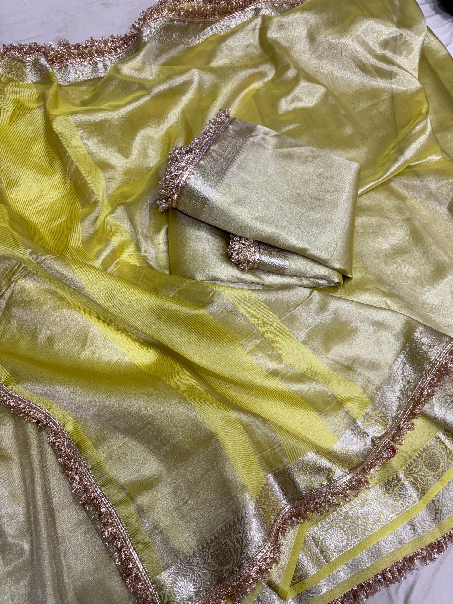 Lemon yellow tissue saree with ornate gold lace border and woven accents