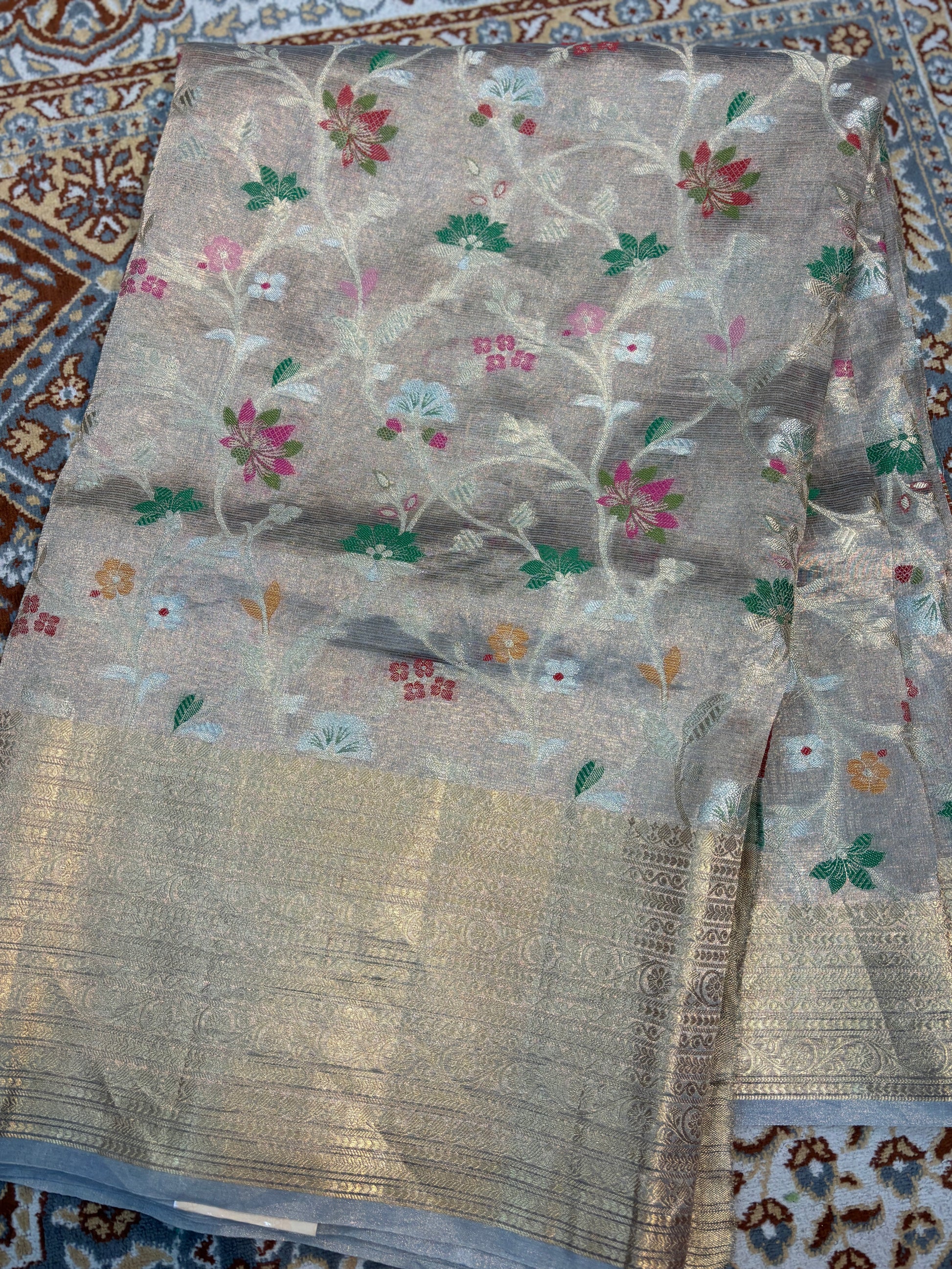 Silver-gray handloom saree with multicolor floral vines and blue border