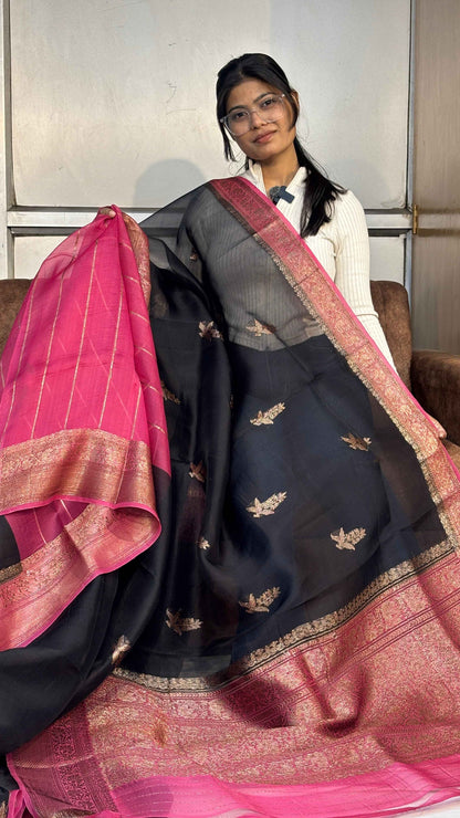 Black silk saree with gold motifs, pink pallu and wide zari border.