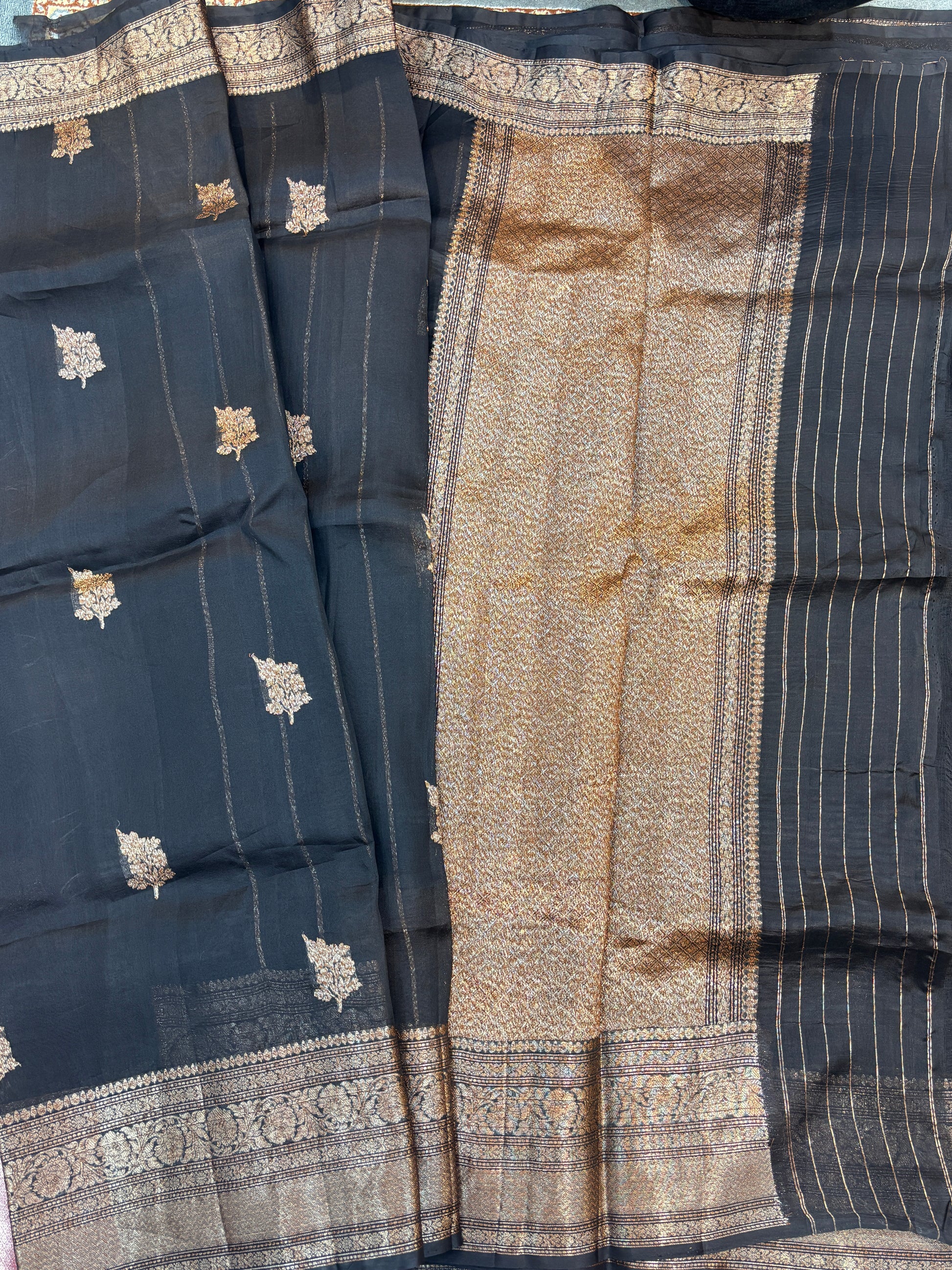 Dark silk saree with gold floral motifs and vertical striped pallu section