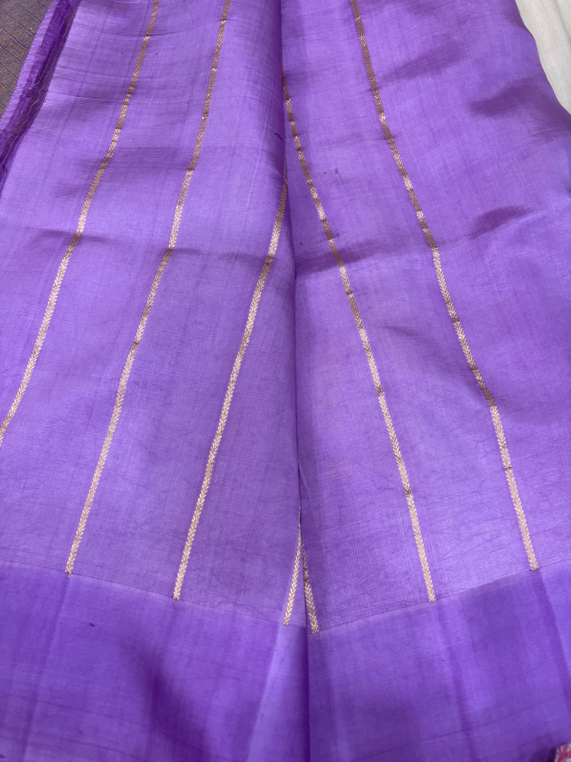 Lavender silk saree close-up with vertical gold zari stripes and light crosshatch texture