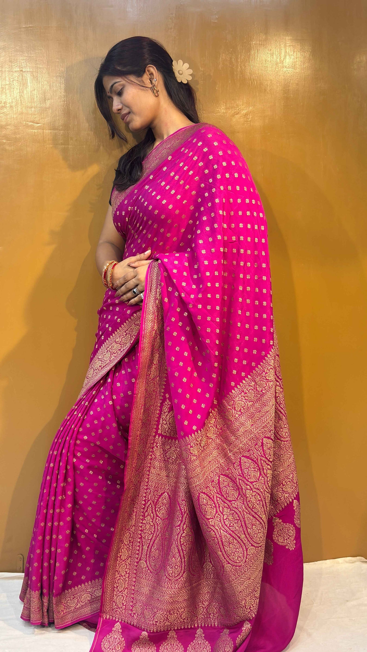 Rani pink saree with wide gold zari border and dense woven motif detailing