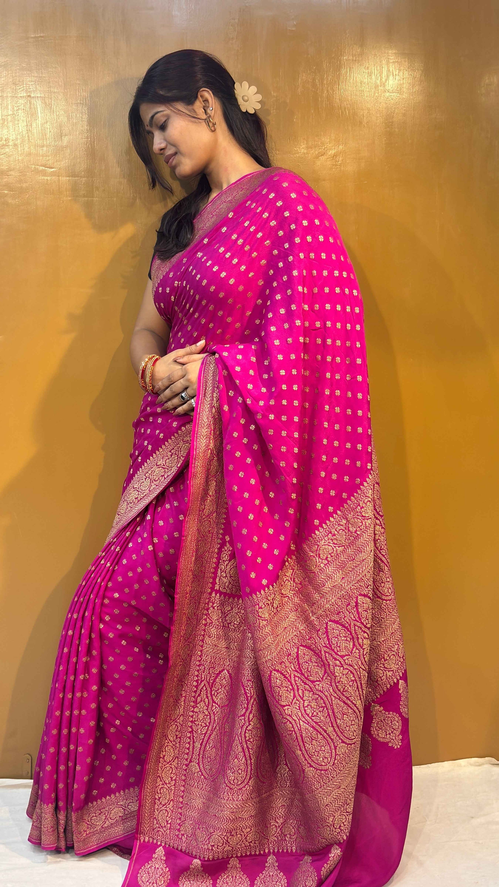 Rani pink saree with wide gold zari border and dense woven motif detailing