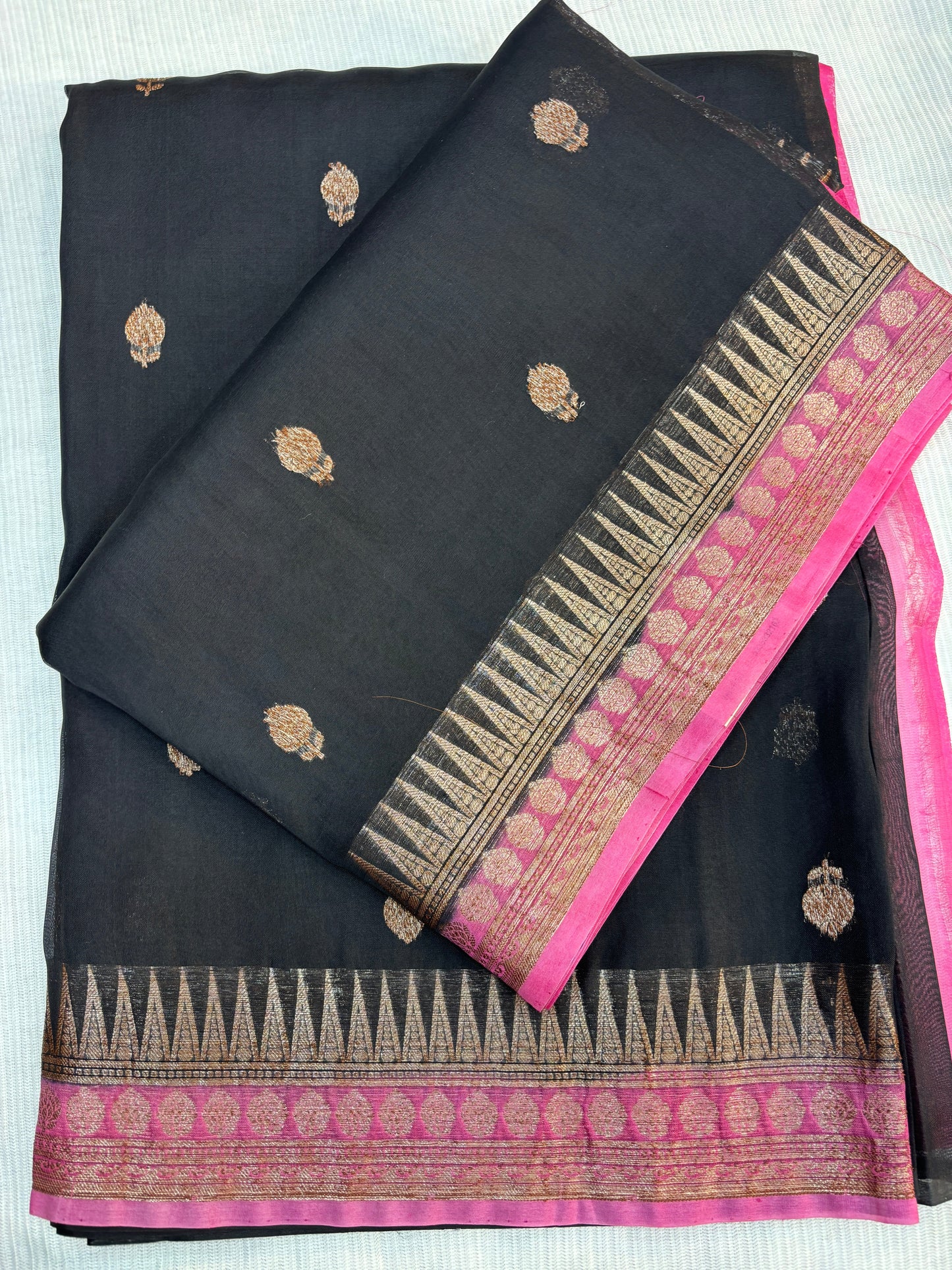 Black silk saree with gold motifs and bright pink zari border