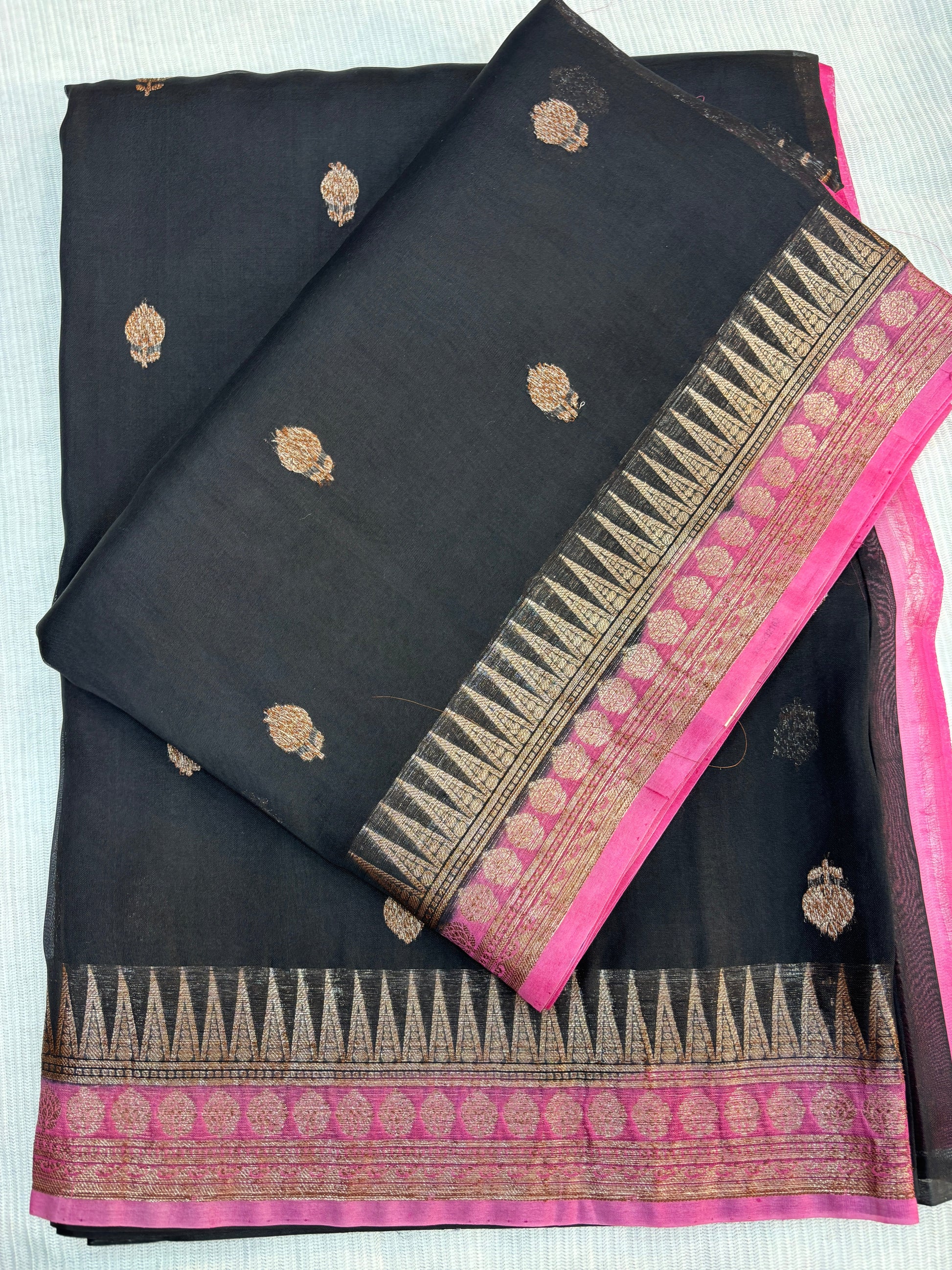 Black silk saree with gold motifs and bright pink zari border