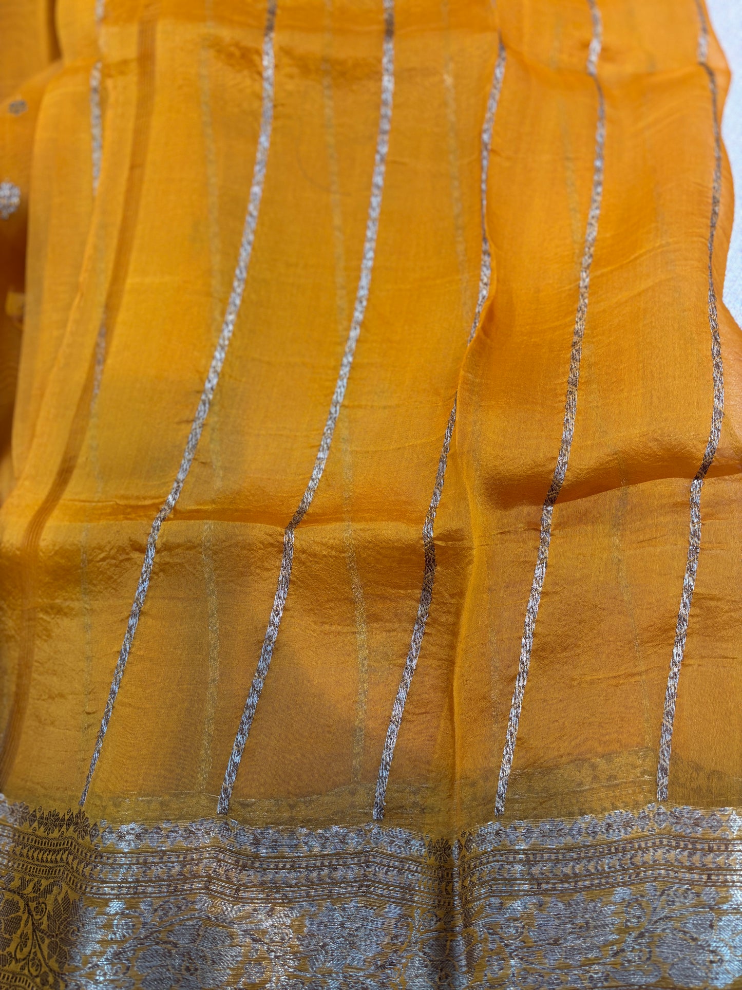 Mustard yellow saree with small silver dot pattern and silver striped border