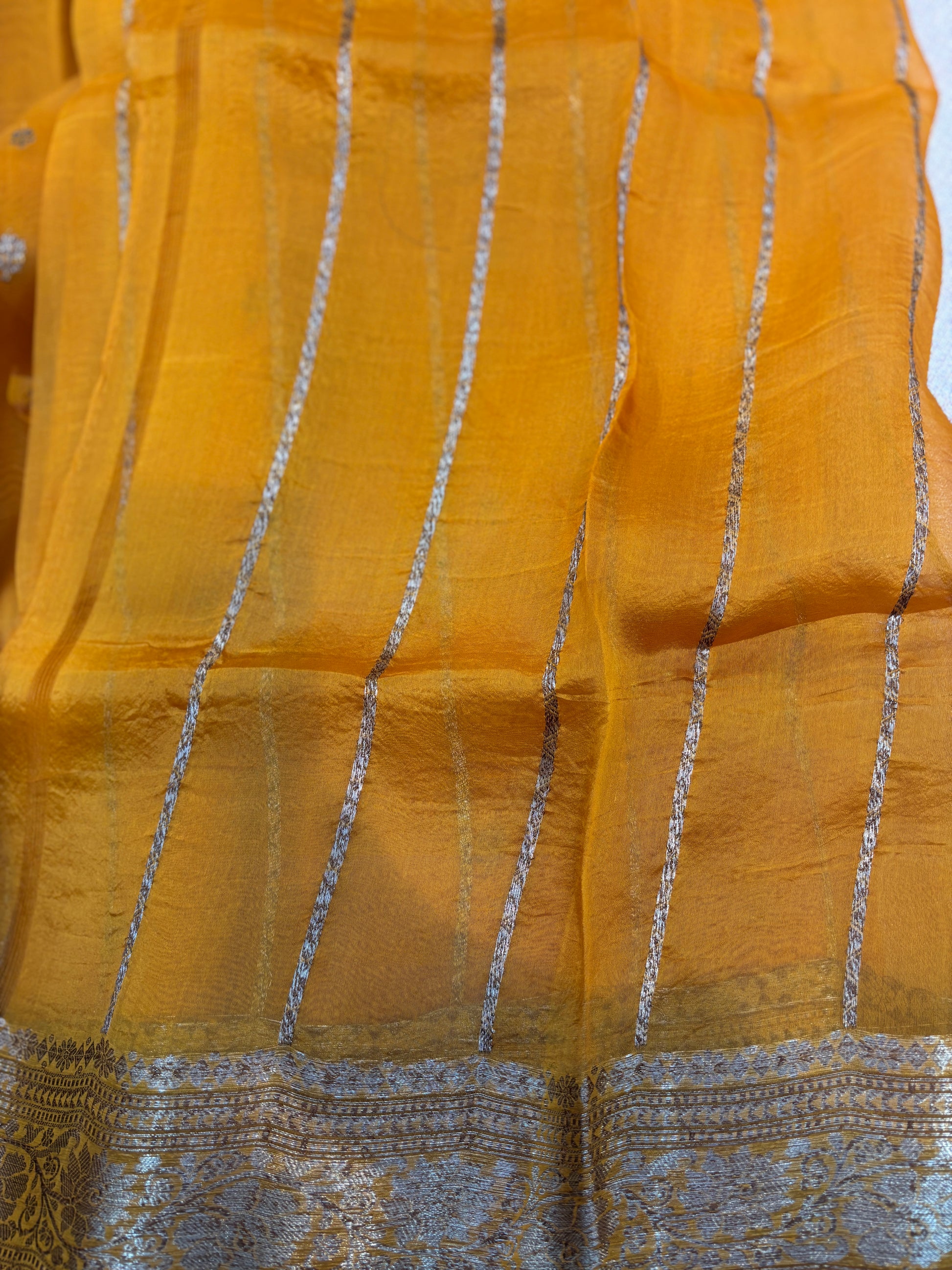 Mustard yellow saree with small silver dot pattern and silver striped border