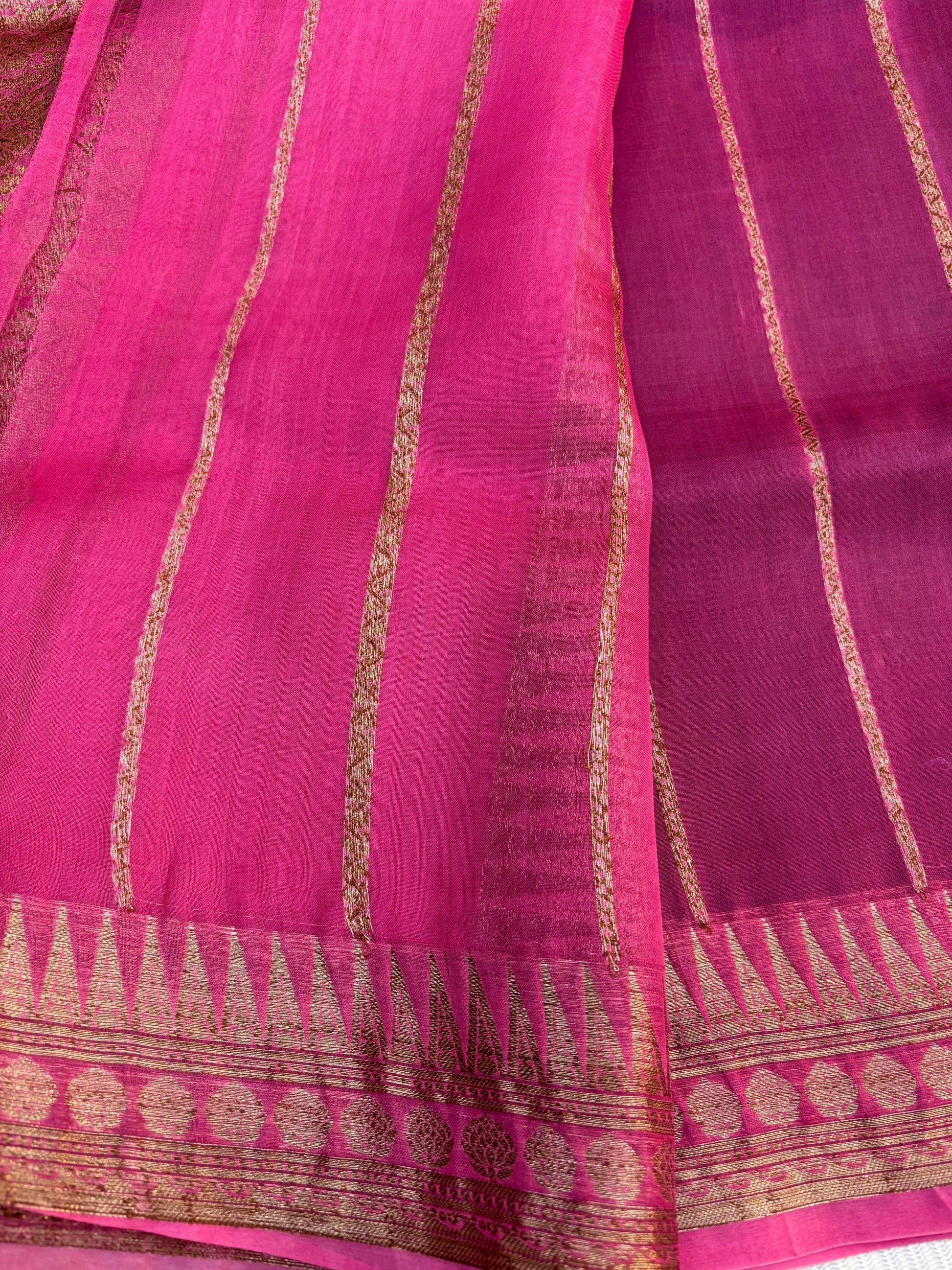 Pink silk saree with gold zari stripes and woven border