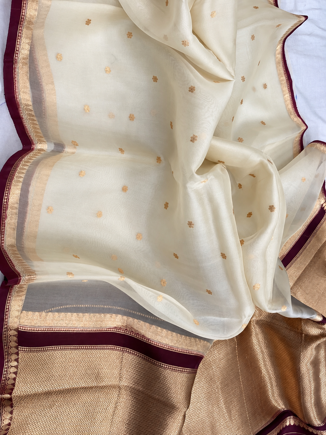 Ivory silk saree with small gold motifs and maroon-gold border
