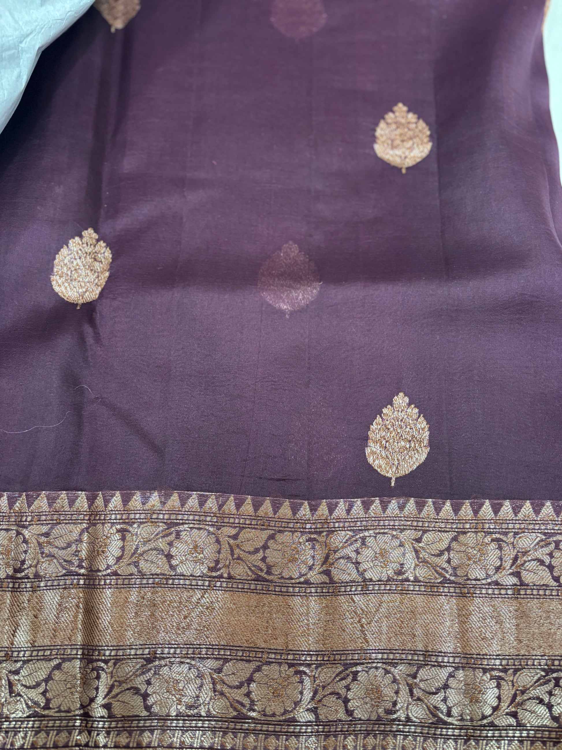 Purple silk saree with scattered gold zari leaf motifs and ornate gold border