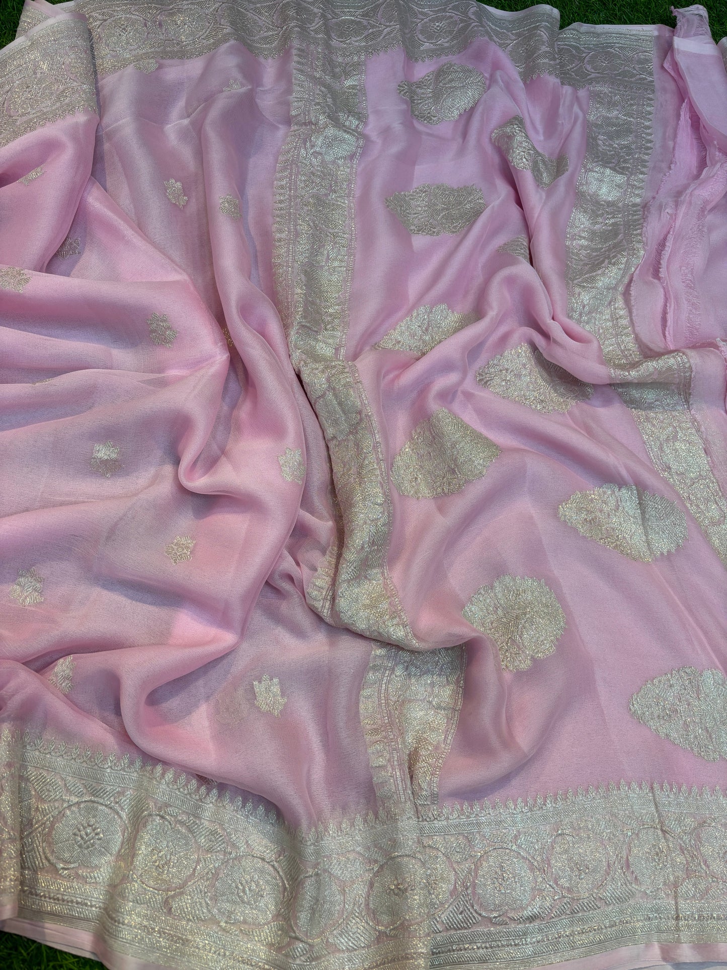 Light pink Banarasi handloom saree with gold-tone motifs and silver-tone border stripe.