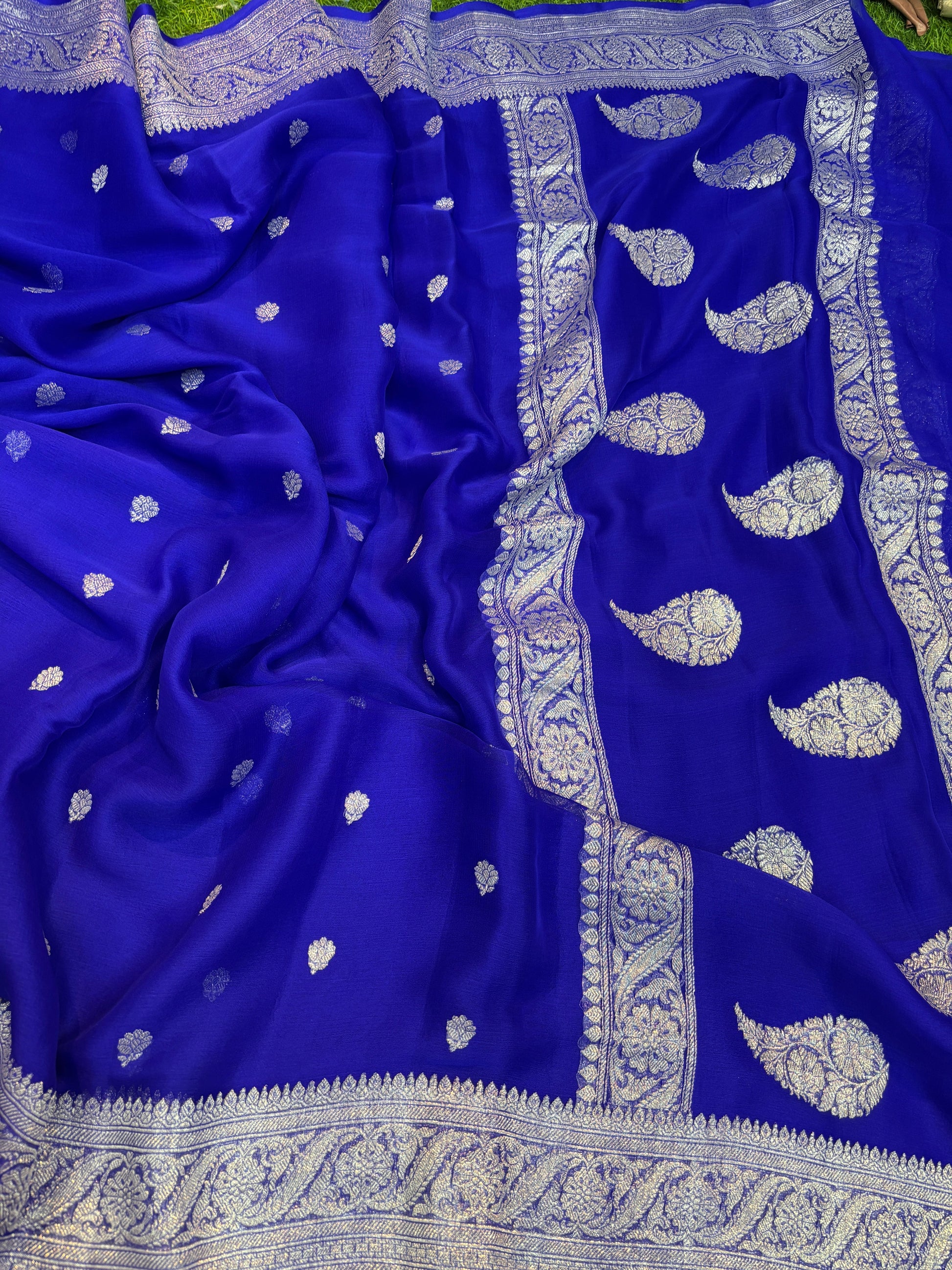 Royal blue Banarasi handloom saree with allover paisley motifs and silver-tone border.