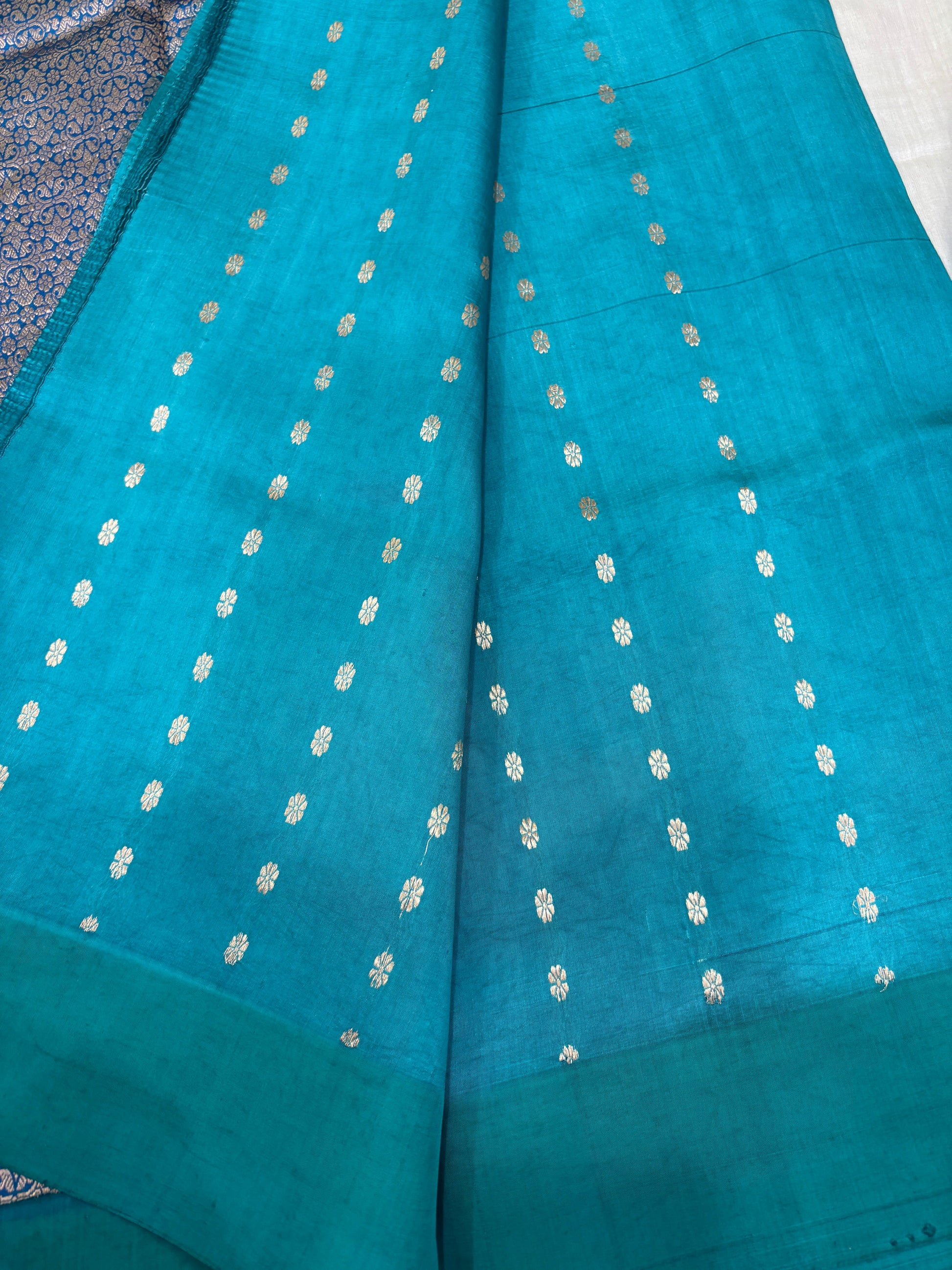 Teal silk saree with small gold dot motifs and woven border