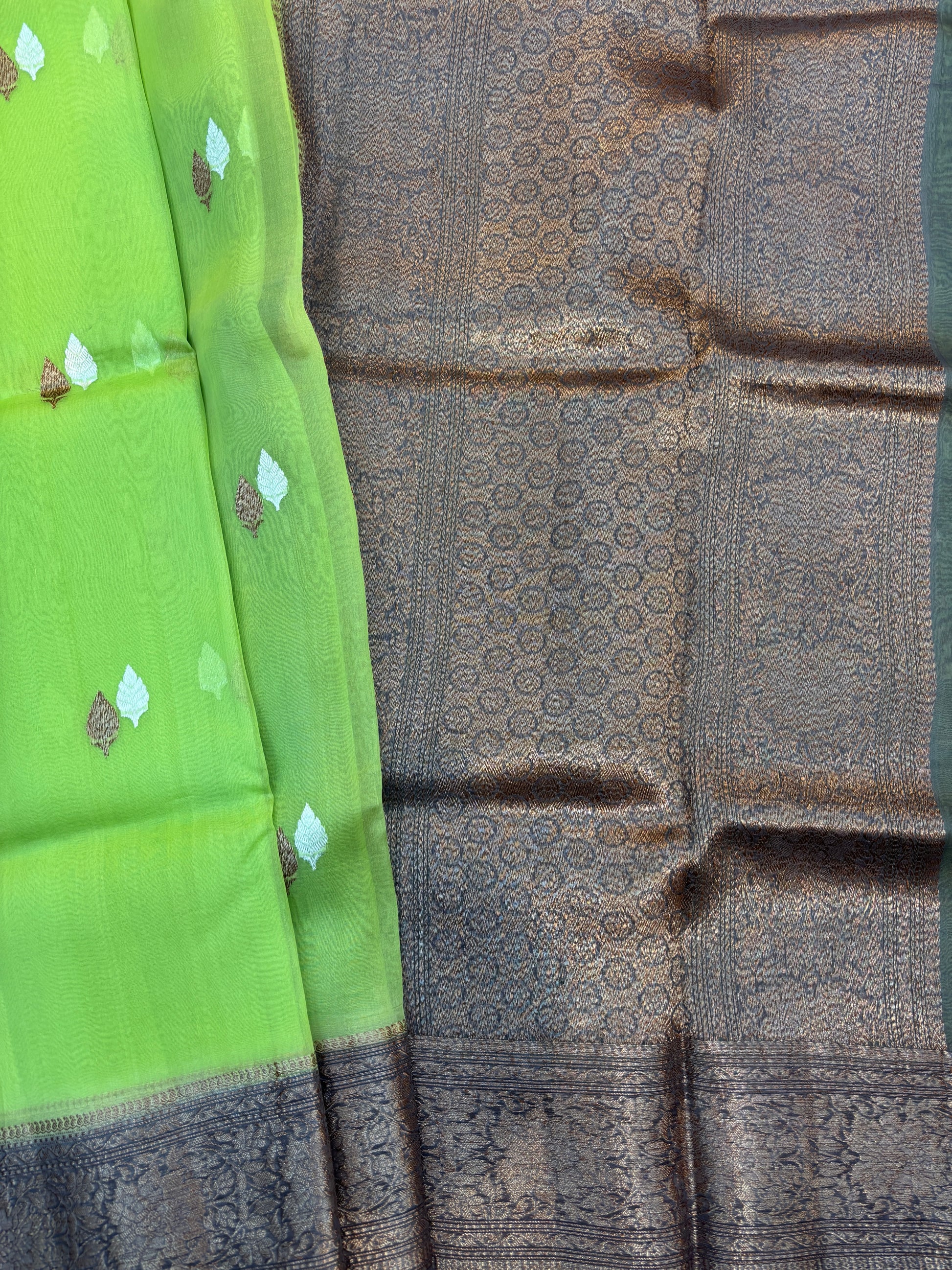 Green silk saree with small gold motifs and charcoal patterned pallu
