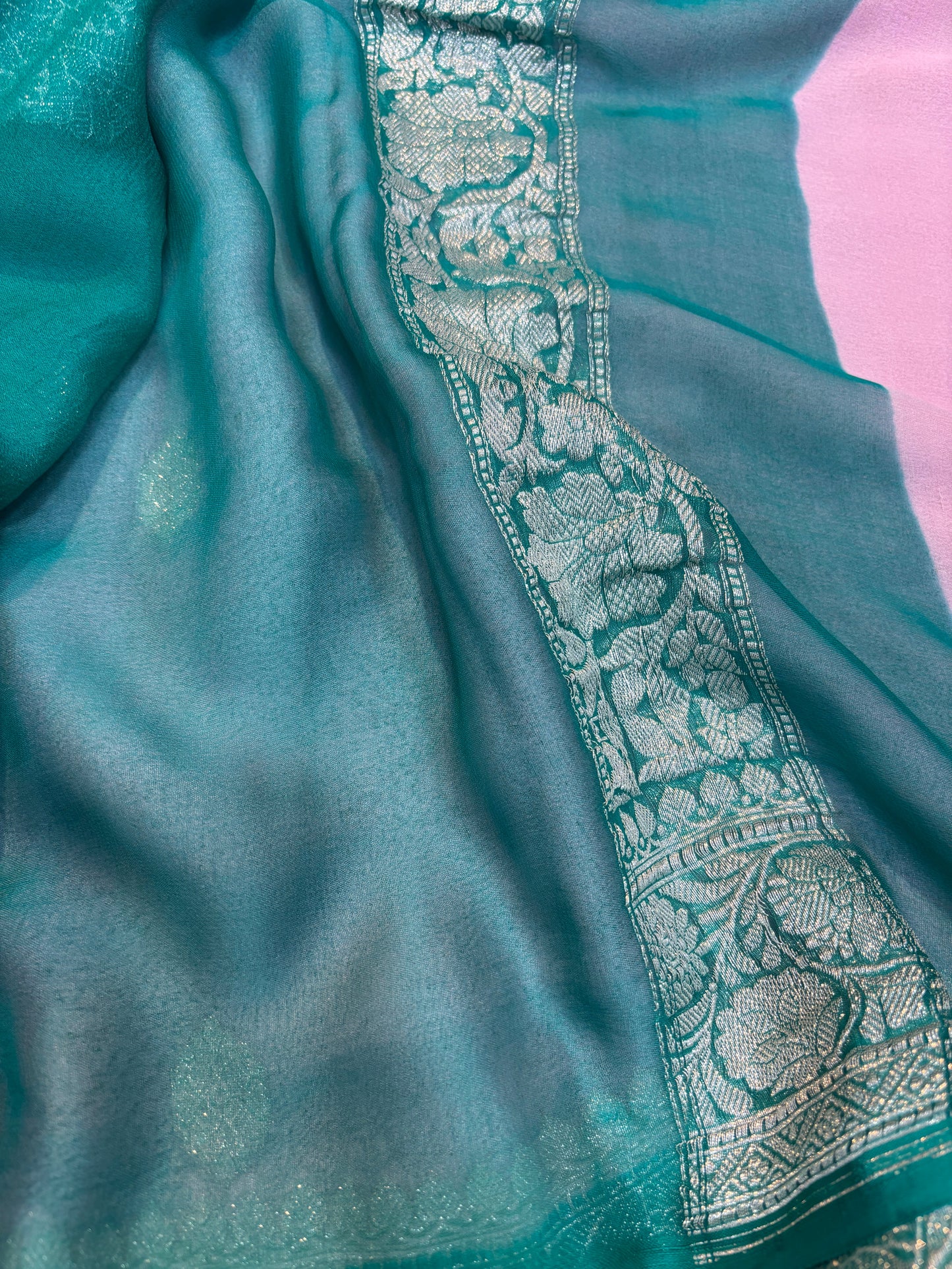 Teal chiffon saree with embroidered silver border detail along the edge