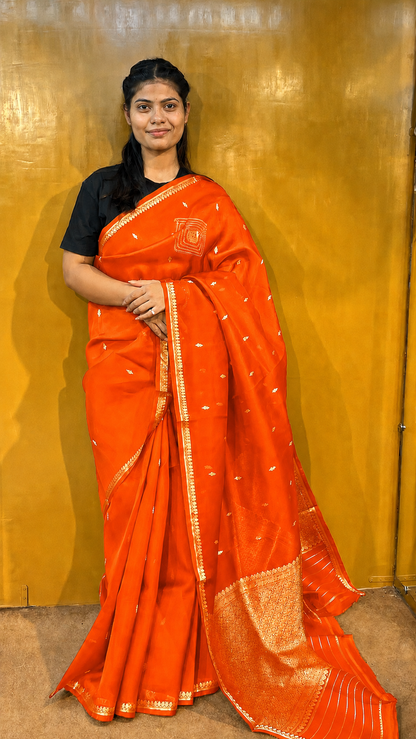 Orange Banarasi handloom saree with gold zari border and small metallic motifs