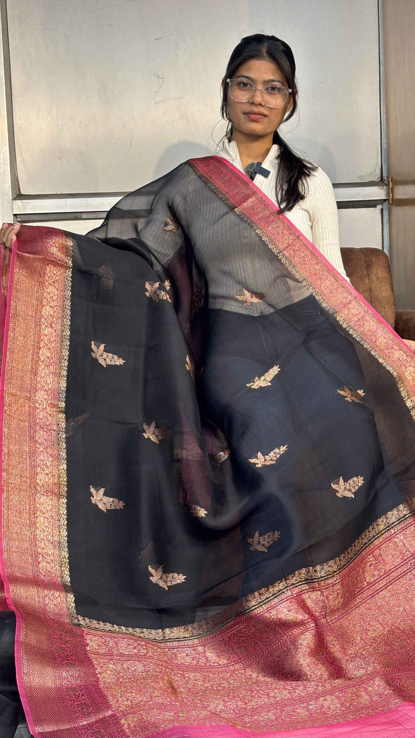 Black silk saree with gold motif buti, pink border and pallu.