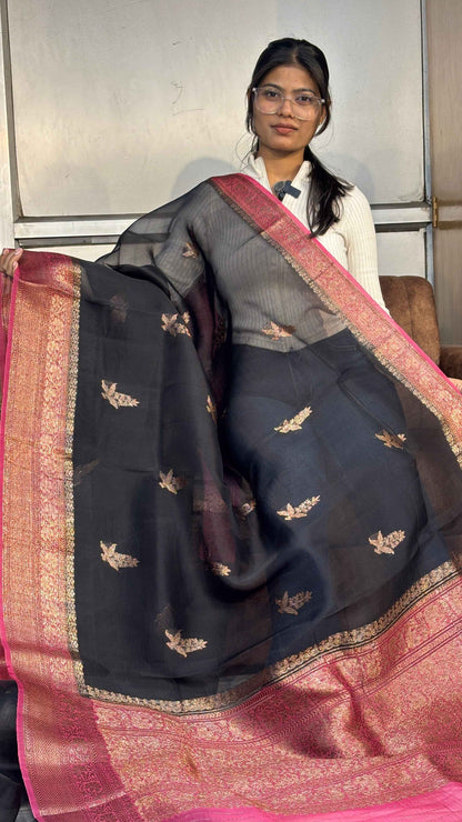 Black silk saree with gold motif buti, pink border and pallu.