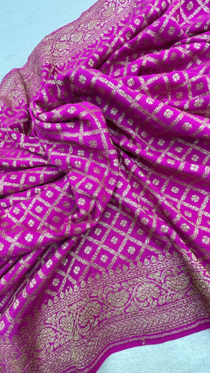 Rani pink saree fabric close-up with gold motifs and ornate zari border