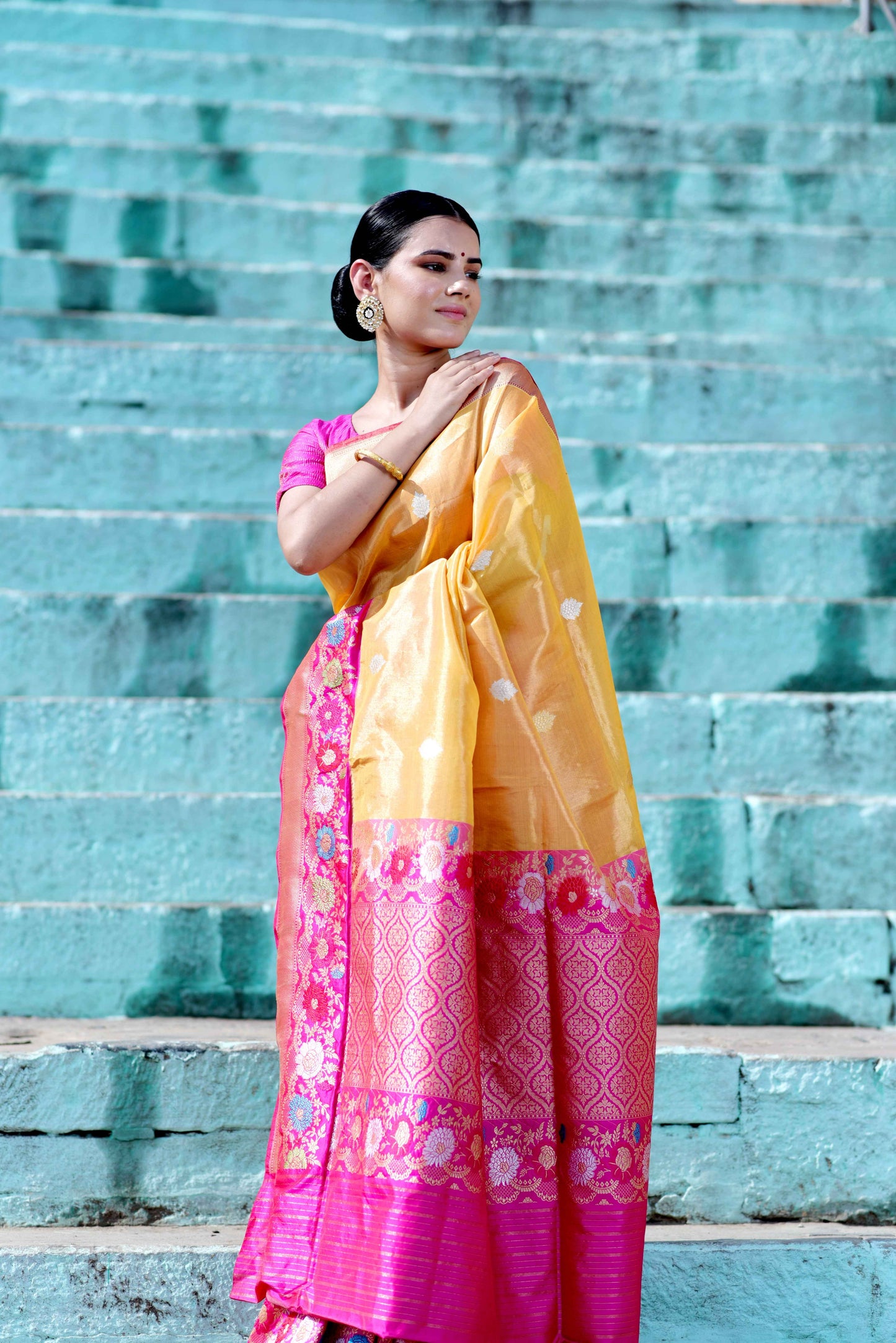 Yellow saree with pink floral border and magenta lower panel, worn with blouse