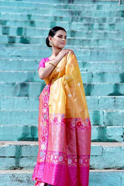 Yellow saree with pink floral border and magenta lower panel, worn with blouse