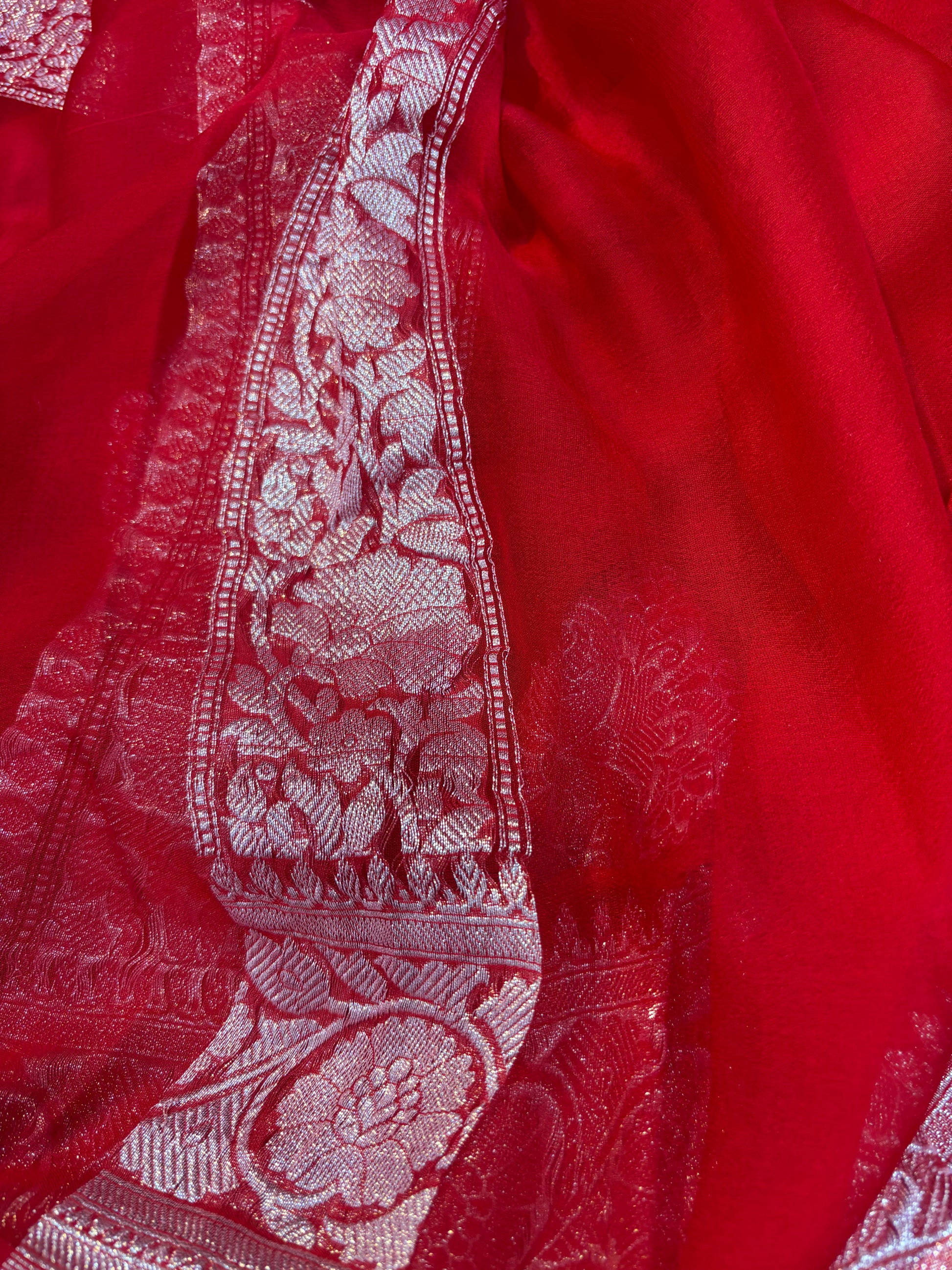 Red chiffon saree with silver zari vertical border and textured embroidered design
