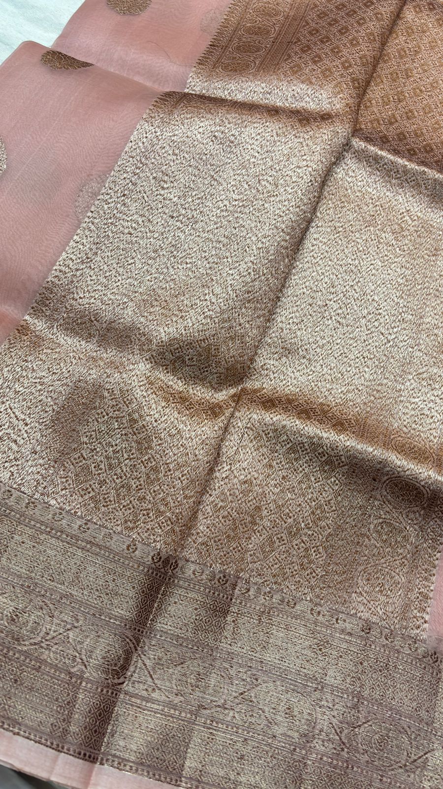 Peach pink saree close-up of textured body with ornate gold zari border