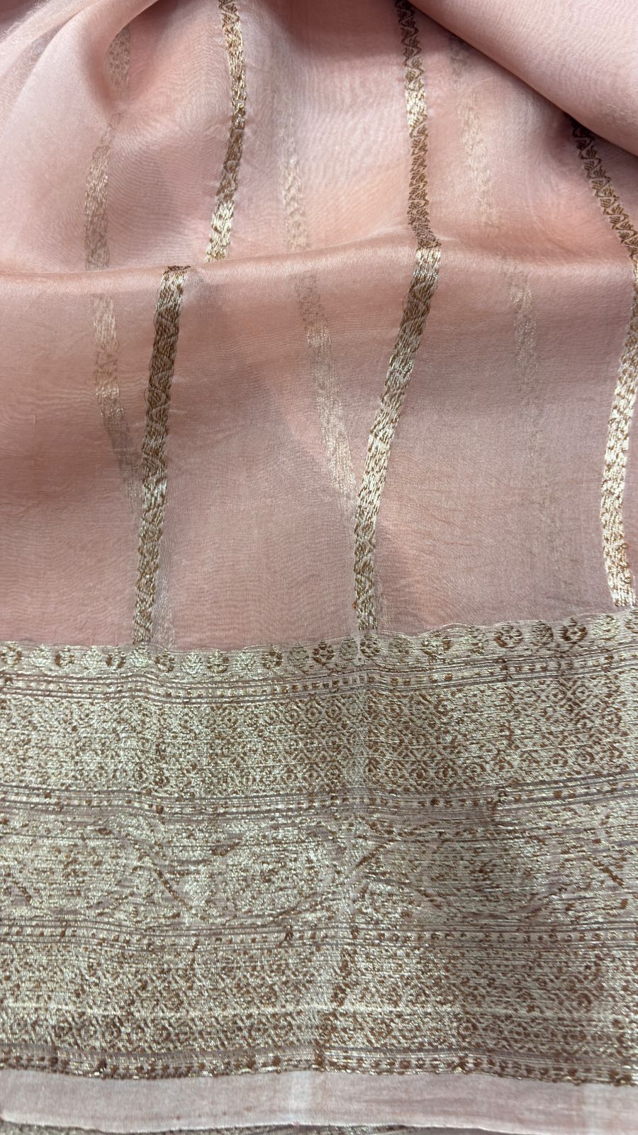 Peach pink saree pallu with vertical gold zari lines and patterned border
